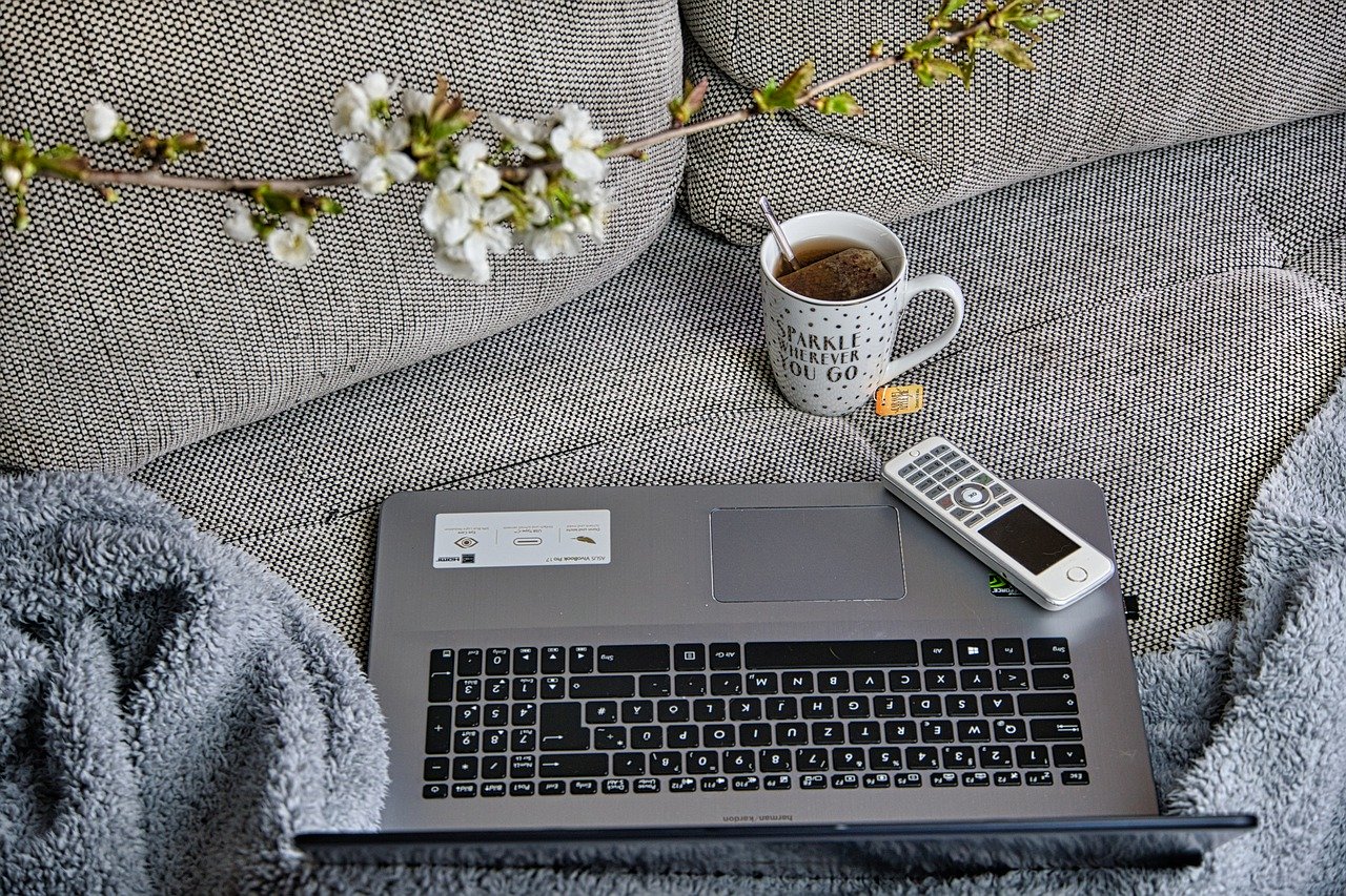 Laptop und Tee auf Couch